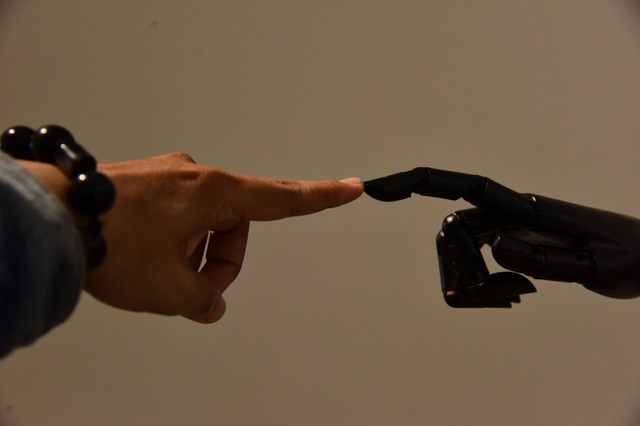 A human hand and a robotic hand extending fingers to touch, symbolizing connection.